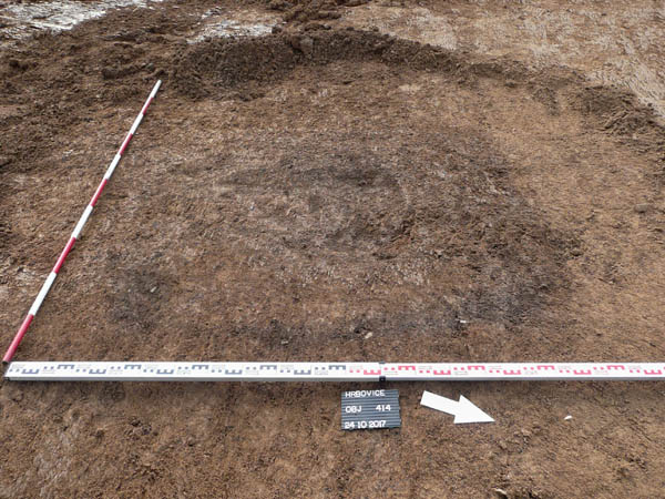Tmavá skvrna indikuje zahloubený archeologický objekt, v tomto případě hrob, výzkum MMUL (foto K. Svoboda)
